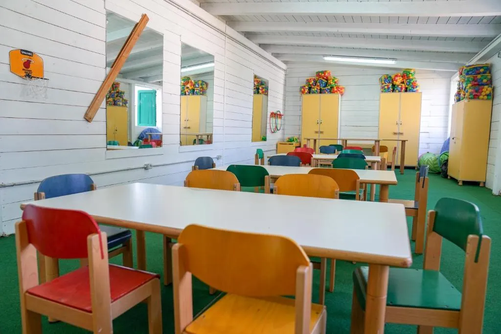 Sala giochi per bambini con tavoli colorati e attrezzature ludiche