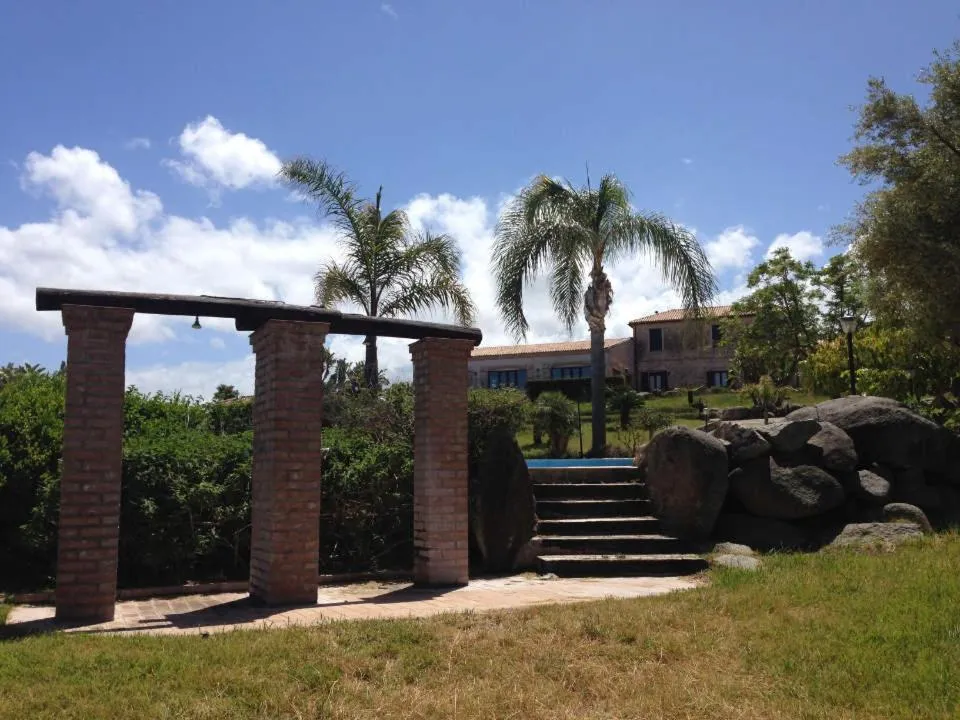 Pergolato in mattoni con scalinata e palme nel giardino del resort