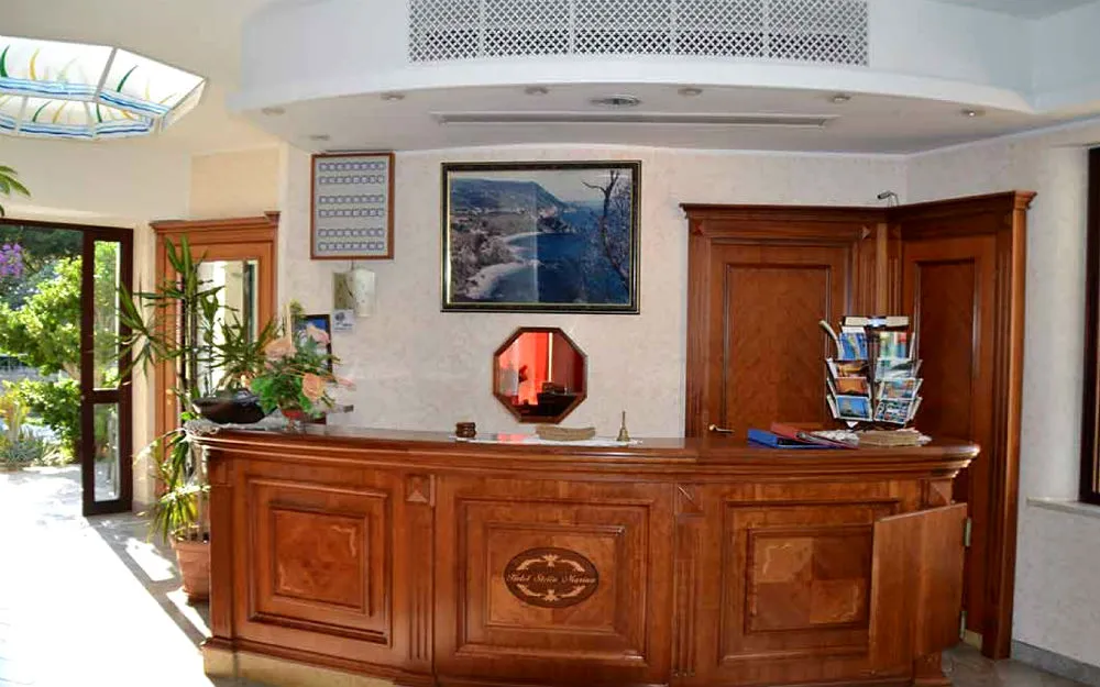 Reception dell'hotel con bancone in legno e arredi classici