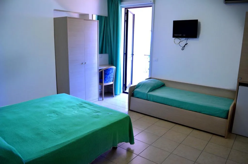 Camera con letto matrimoniale, divano letto, armadio e TV a parete