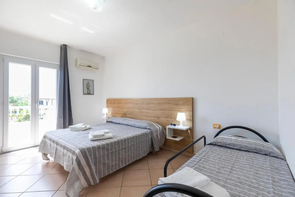 Camera tripla luminosa con letto matrimoniale e letto singolo, pavimento in cotto e balcone