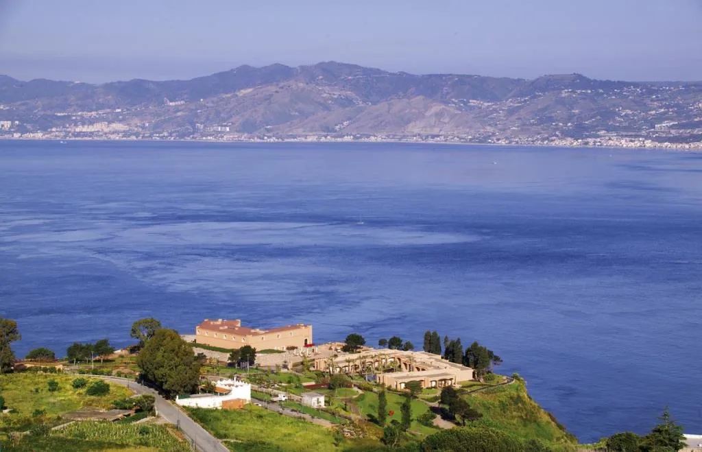 Vista panoramica del resort sulla scogliera affacciato sul golfo con montagne sullo sfondo